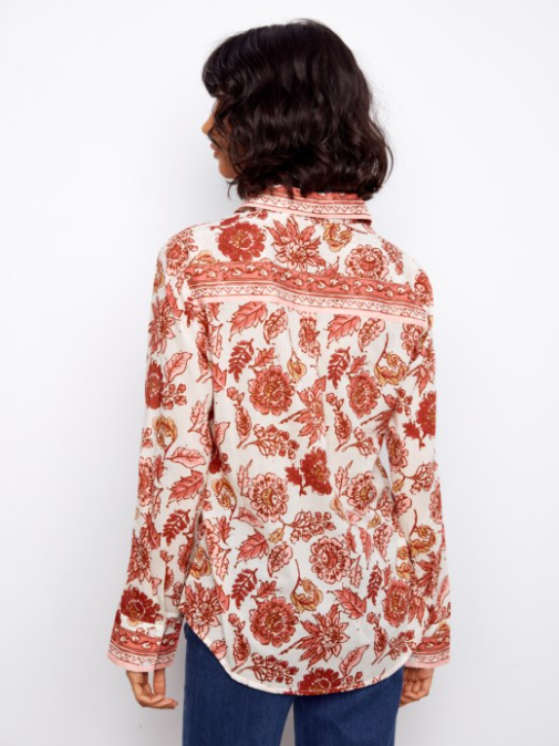 Person wearing a red floral patterned shirt on a white background