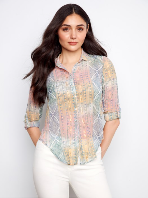 Woman wearing a colorful patterned shirt against a white background