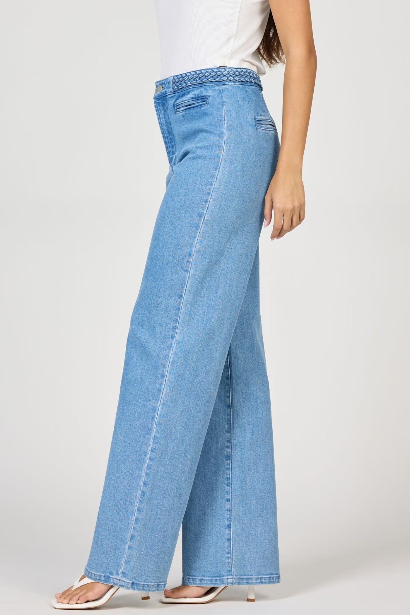 Light blue jeans worn by a person on a white background