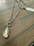 Necklace with a teardrop-shaped pendant on a wooden surface