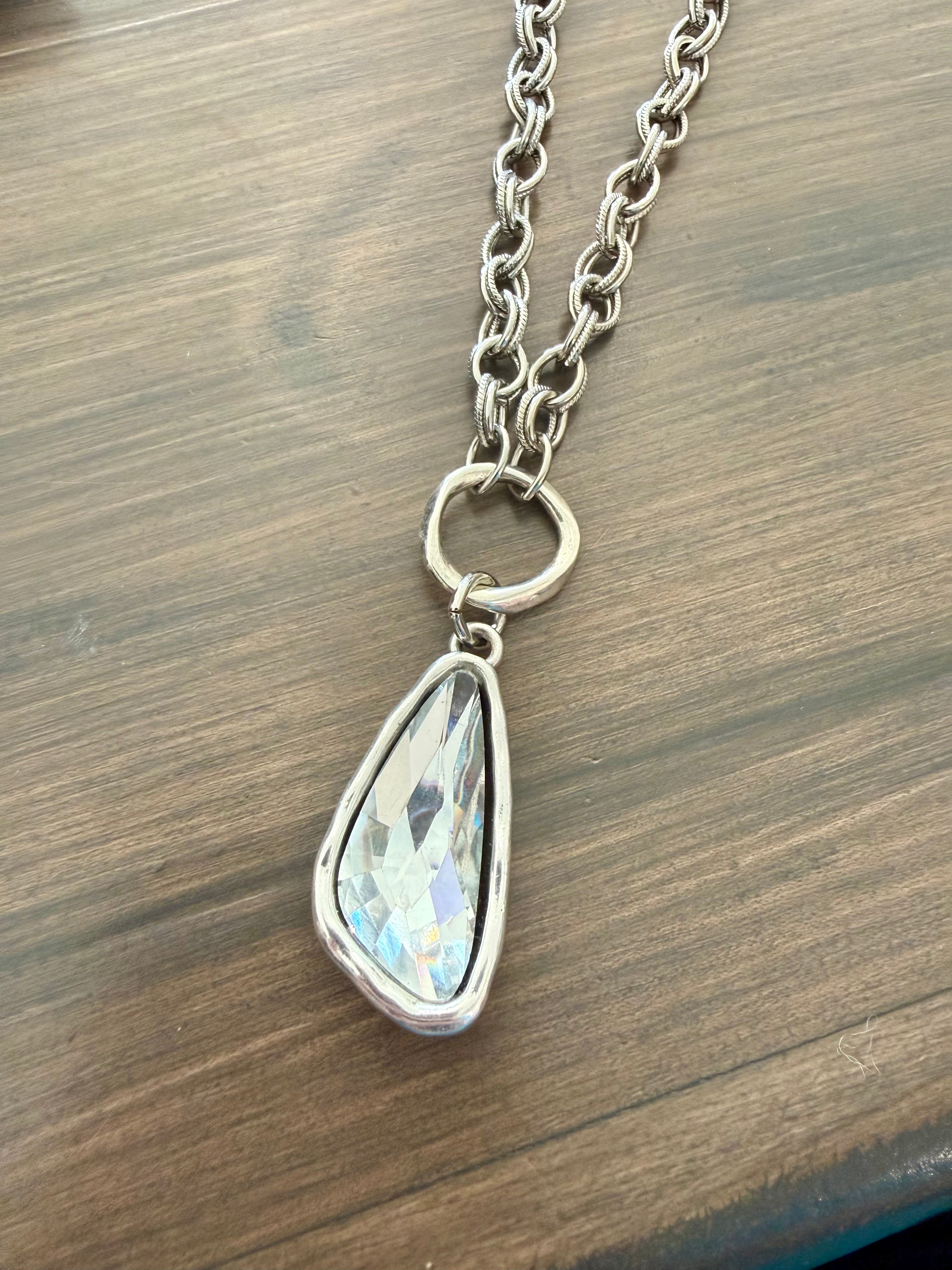Necklace with a teardrop-shaped pendant on a wooden surface
