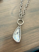 Necklace with a teardrop-shaped pendant on a wooden surface
