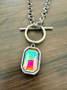 Necklace with a colorful pendant on a wooden surface