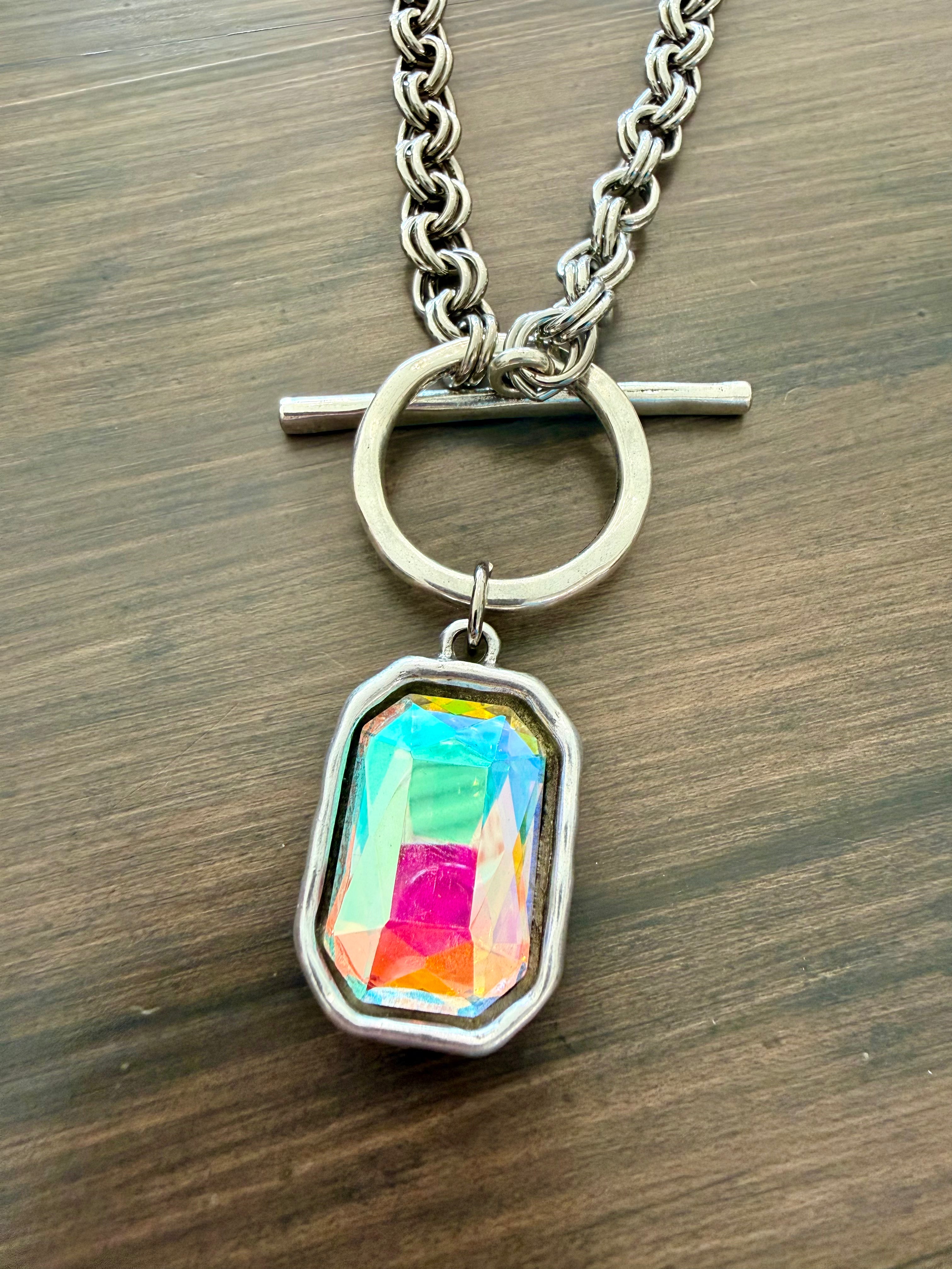 Necklace with a colorful pendant on a wooden surface