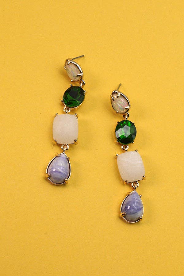 Pair of earrings with multicolored gemstones on a yellow background