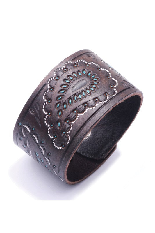Brown leather cuff with intricate patterns on a white background