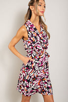 Woman wearing a colorful patterned dress against a plain background