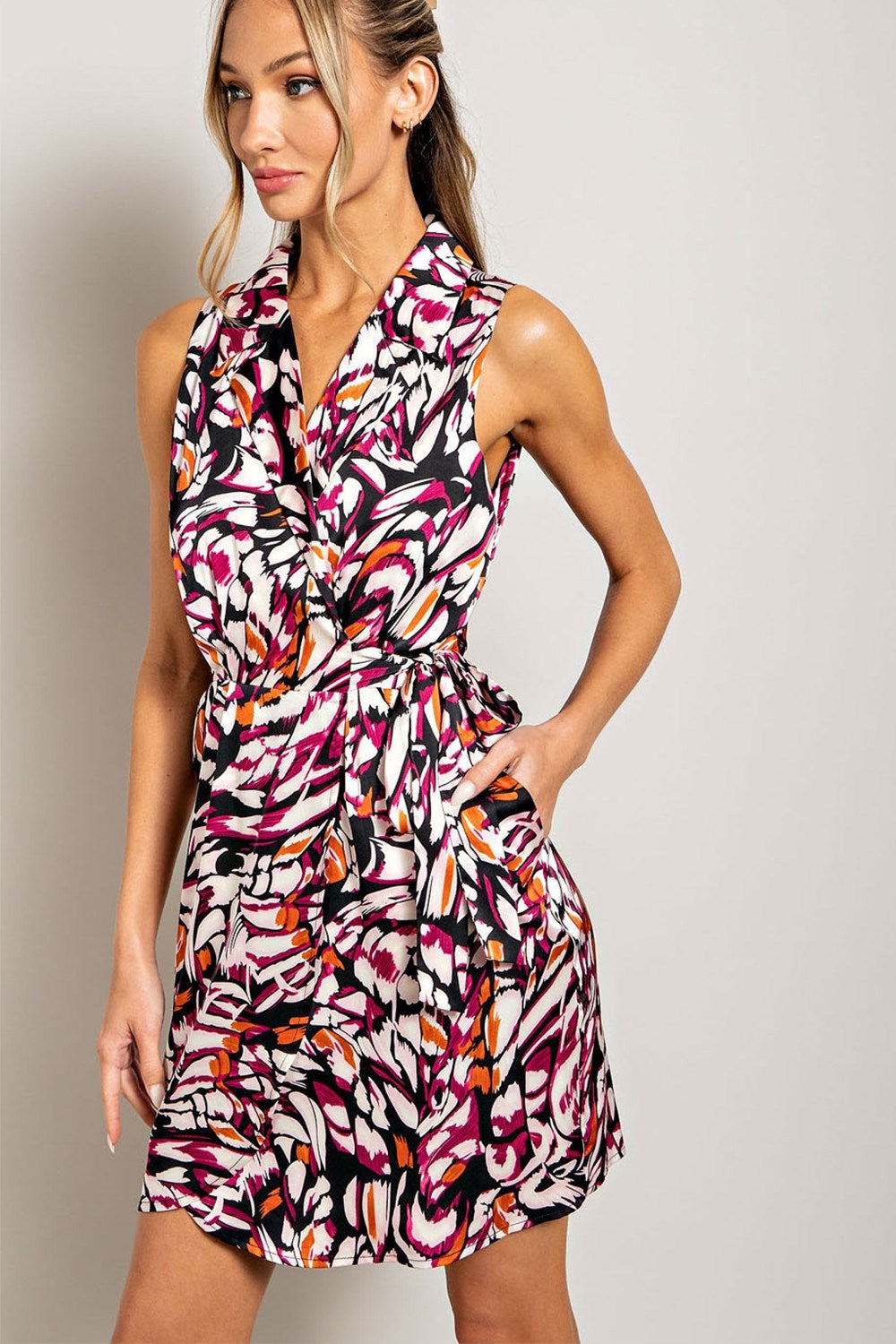 Woman wearing a colorful patterned dress against a plain background