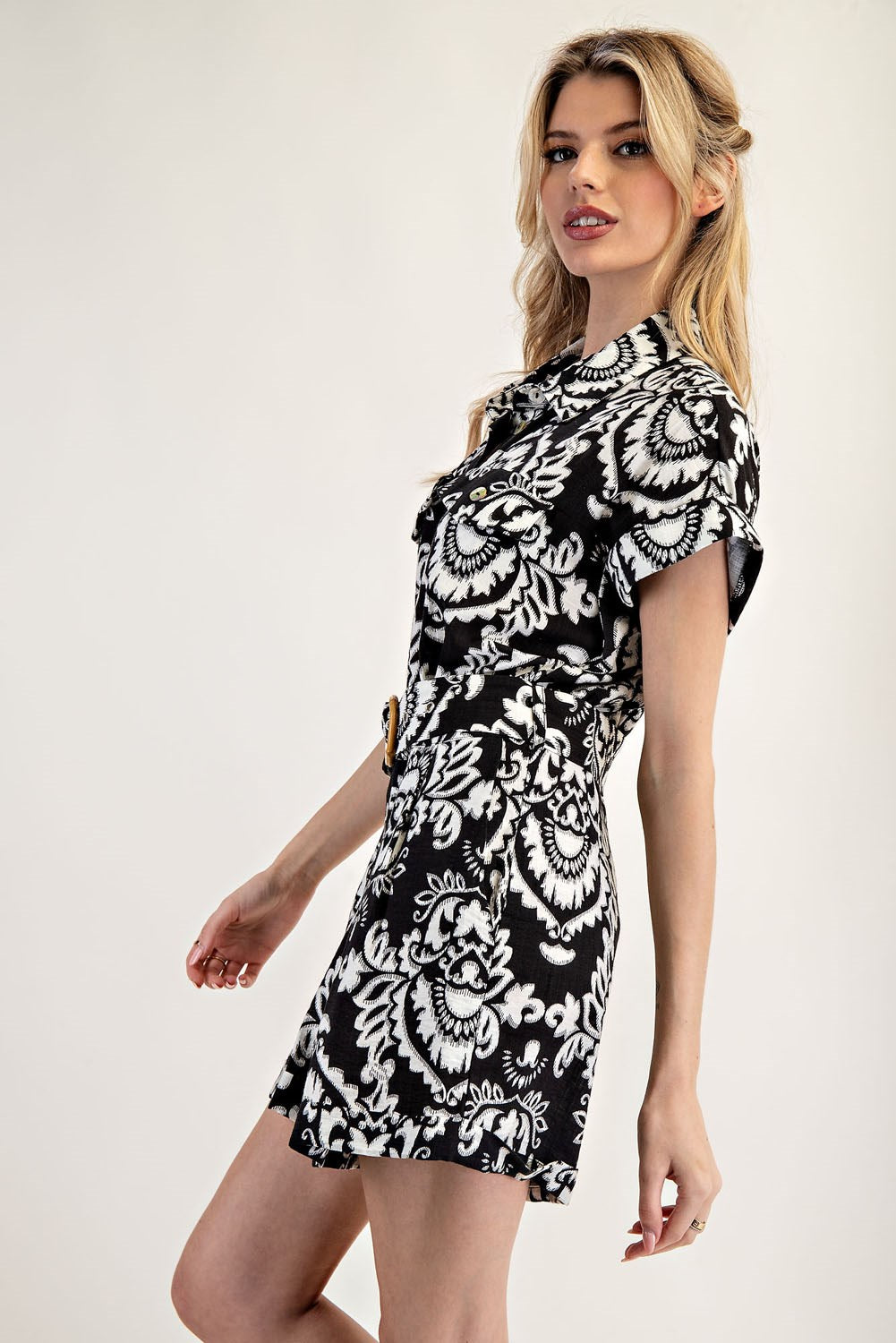 Woman wearing a black and white patterned dress on a white background