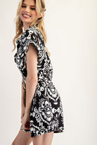Woman wearing a black and white patterned dress on a white background