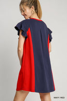 Woman wearing a navy and red dress on a gray background