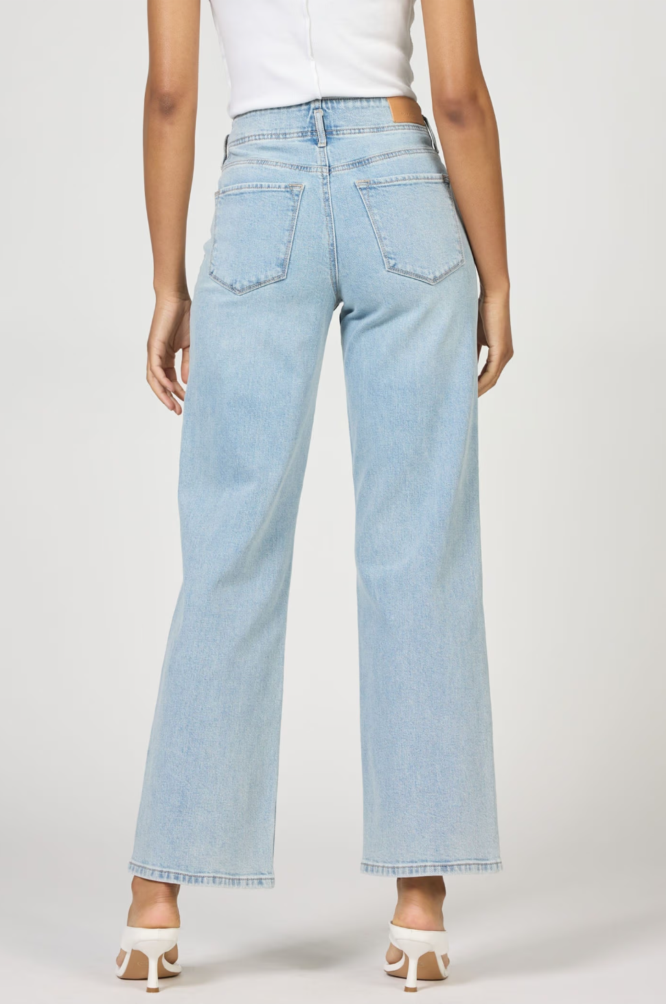 Light blue jeans worn by a person on a white background