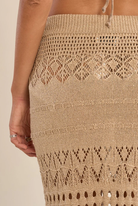 Gold crochet skirt with intricate patterns on a beige background