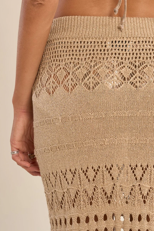 Gold crochet skirt with intricate patterns on a beige background
