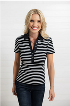 Woman wearing a black and white striped shirt with a plain background