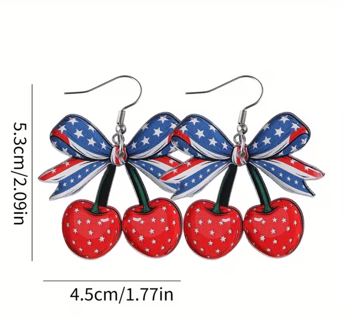 Earrings with American flag bow and cherries on a white background