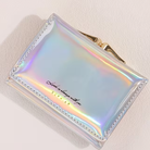 Iridescent clutch bag with gold accents on a light background