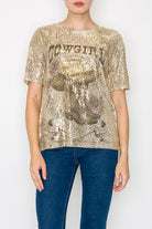 Person wearing a gold sequin t-shirt with text and blue jeans on a white background