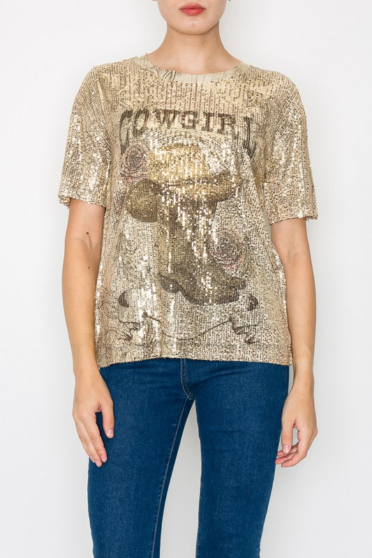 Person wearing a gold sequin t-shirt with text and blue jeans on a white background