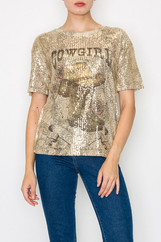 Person wearing a gold sequin t-shirt with text and blue jeans on a white background