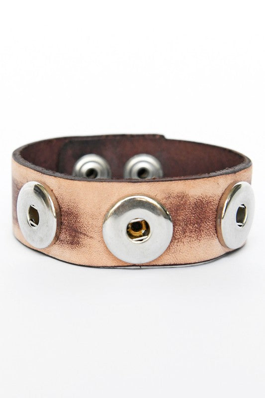 Brown leather bracelet with silver buttons on a white background
