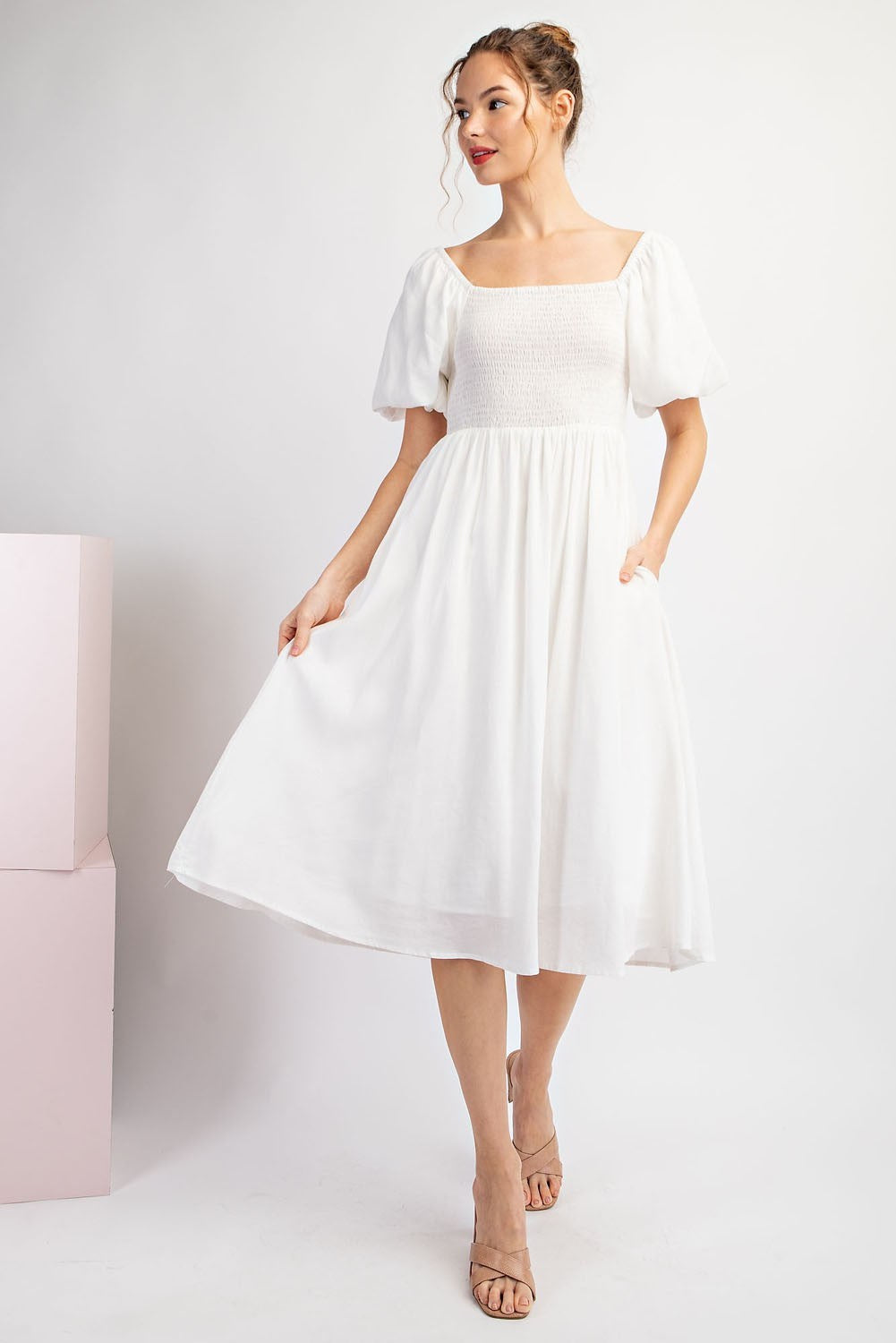 Woman wearing a white dress with a plain background