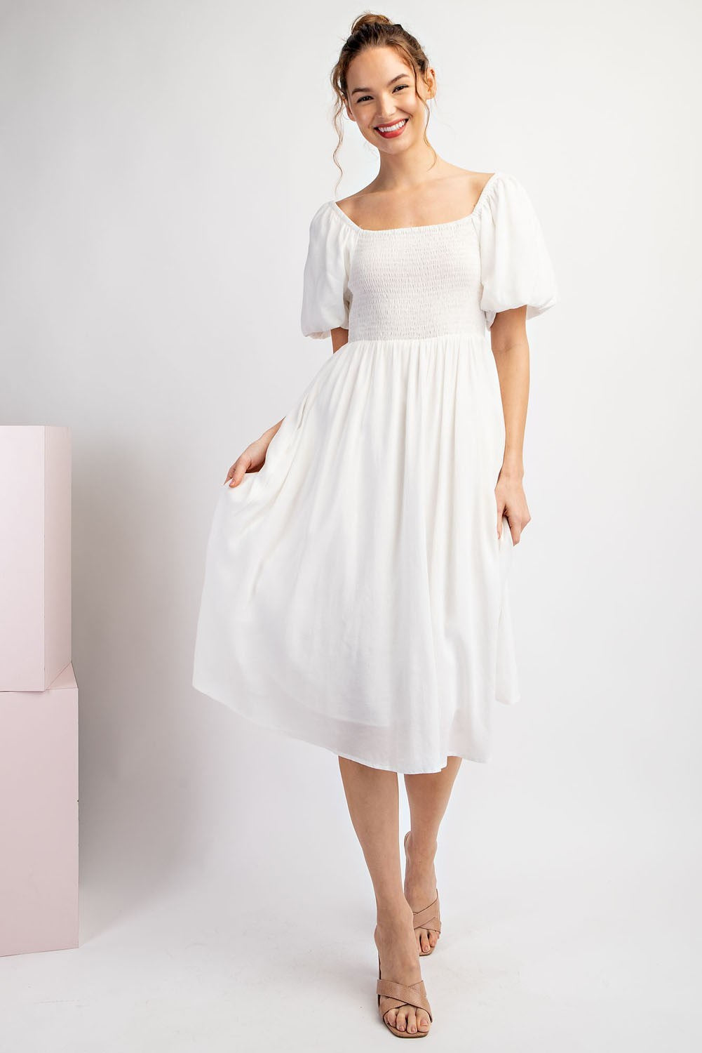 Woman wearing a white dress against a plain background