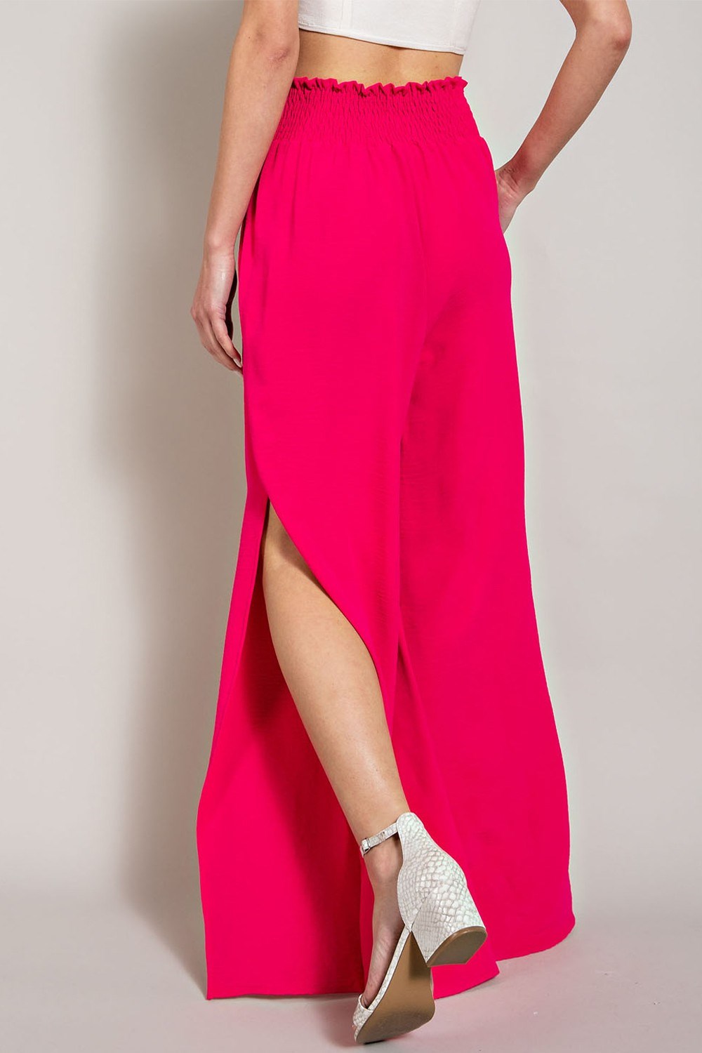 Person wearing a bright pink skirt with a plain background