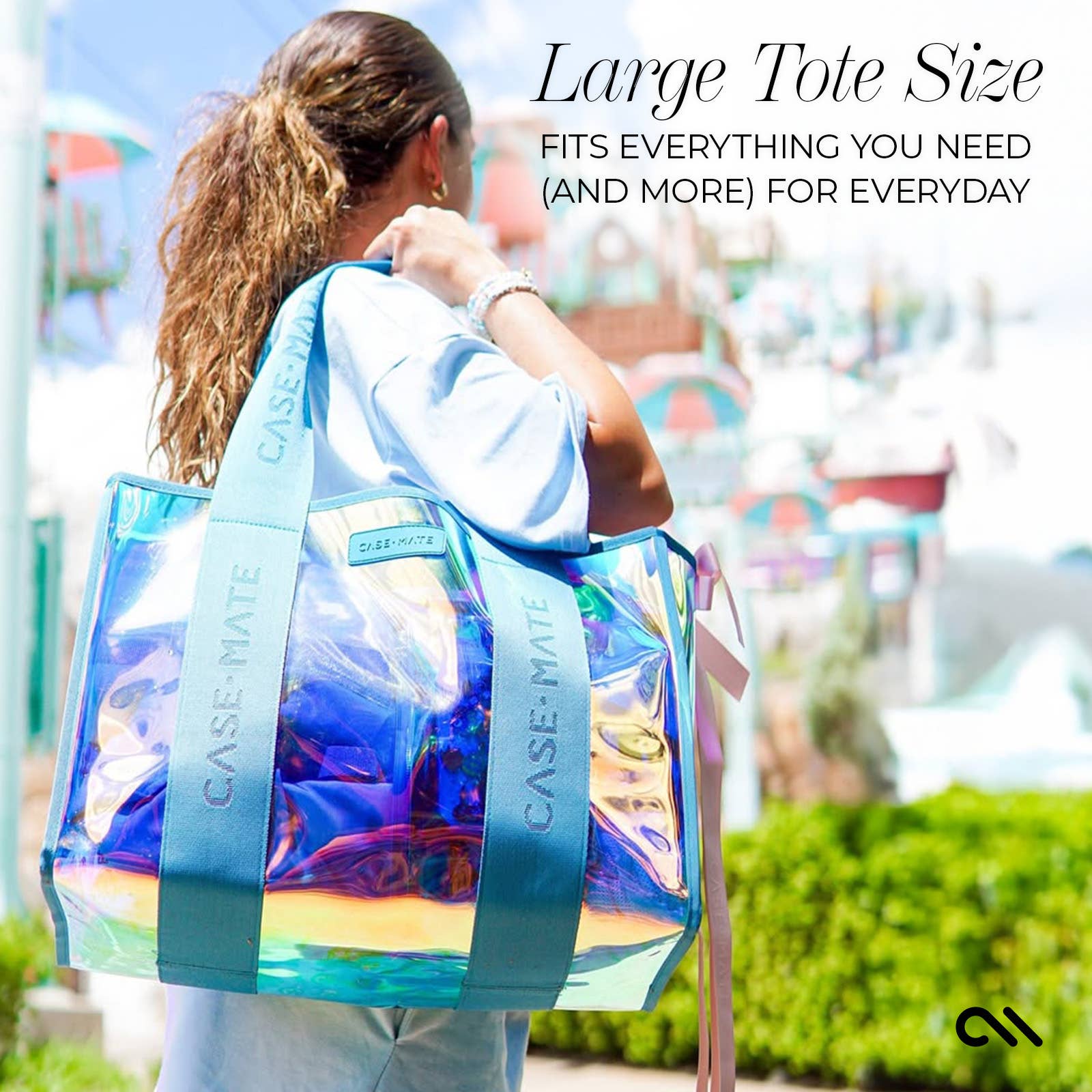 Person holding a large, colorful tote bag with text about its size and functionality.