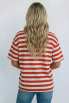 Person wearing a red and white striped shirt with a plain background